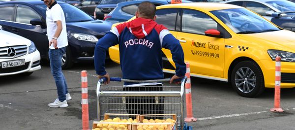Мужчина с толстовке с надписью Россия везет тележку с абрикосами Мужчина с толстовке с надписью Россия везет тележку с абрикосами - Sputnik Армения