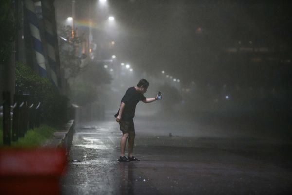 Мужчина на пляже Хэундэ в Пусане во время тайфуна Майсак в Южной Корее - Sputnik Армения