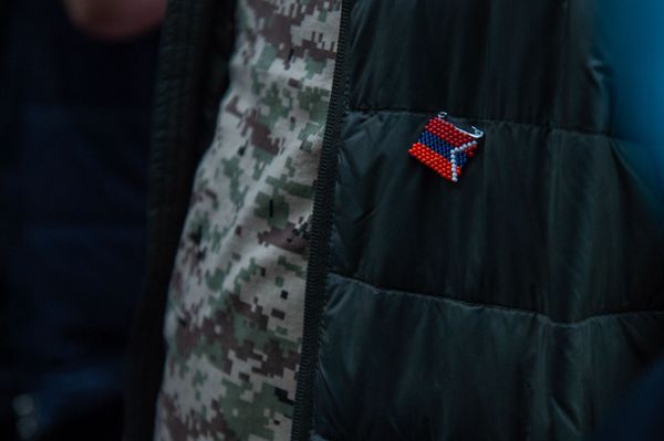 Значок в виде флага Карабаха на участнике акции в поддержку признания независимости Карабаха перед зданием ООН в Армении (13 октября 2020). Еревaн - Sputnik Армения