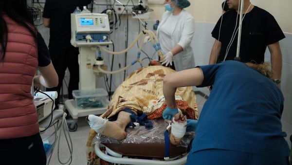 Медработники оперируют раненного мужчину во время обстрелов медицинского центра Степанакерта (28 октября 2020). Карабах - Sputnik Армения