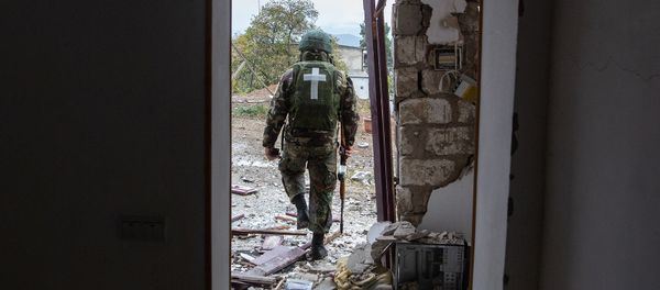 Военнослужащий возле дома, поврежденного в результате обстрела Степанакерта (6 ноября 2020). Карабах - Sputnik Արմենիա