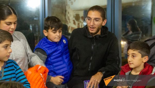 Волонтер из Диаспоры Седрак Балян с карабахскими детьми в отеле Гориса Волонтер из Диаспоры Седрак Балян с карабахскими детьми в отеле Гориса - Sputnik Армения