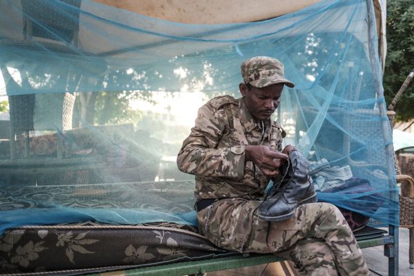 Боец спецназа Амхара чинит ботинок в импровизированном лагере в Хумере, Эфиопия - Sputnik Армения