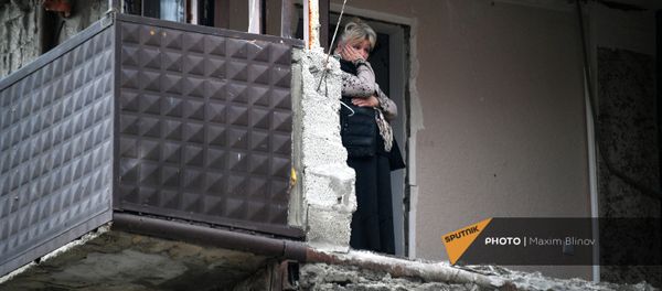 Женщина в своей квартире дома в Степанакерте, пострадавшего во время обстрела - Sputnik Արմենիա