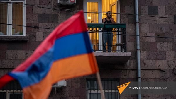 Житель столицы наблюдает за шествием оппозиции с требованием отставки премьер-министра (5 декабря 2020). Еревaн - Sputnik Армения