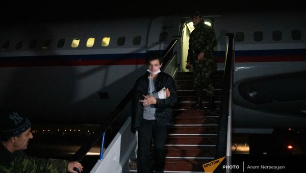 Пленные спускаются по трапу самолета в аэропорту Эребуни (14 декабря 2020). Еревaн - Sputnik Армения