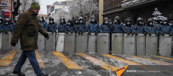 Мужчина проходит мимо полицейского кордона на перекрестке проспекта Тиграна Меца и улицы Мелика Адамяна (24 декабря 2020). Еревaн Мужчина проходит мимо полицейского кордона на перекрестке проспекта Тиграна Меца и улицы Мелика Адамяна (24 декабря 2020). Еревaн - Sputnik Արմենիա