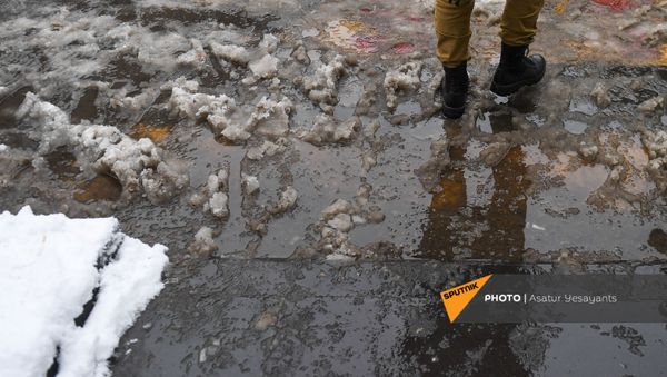 Мужчина проходит по слякоти (24 декабря 2020). Еревaн Мужчина проходит по слякоти (24 декабря 2020). Еревaн - Sputnik Արմենիա