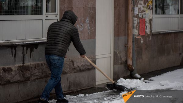 Молодой человек очищает от снега улицу - Sputnik Արմենիա