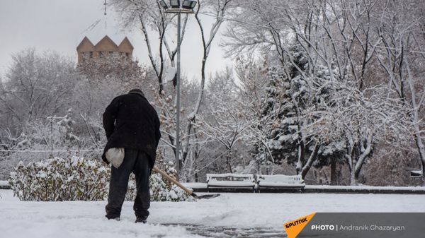 Мужчина очищает от снега улицу - Sputnik Արմենիա