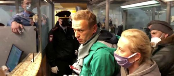 Сотрудники правоохранительных органов разговаривают с лидером российской оппозиции Алексеем Навальным перед тем, как увезти его в аэропорт (17 января 2021). Москва - Sputnik Արմենիա