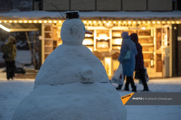 Женщины проходят мимо снеговика в ереванском вернисаже Женщины проходят мимо снеговика в ереванском вернисаже - Sputnik Армения