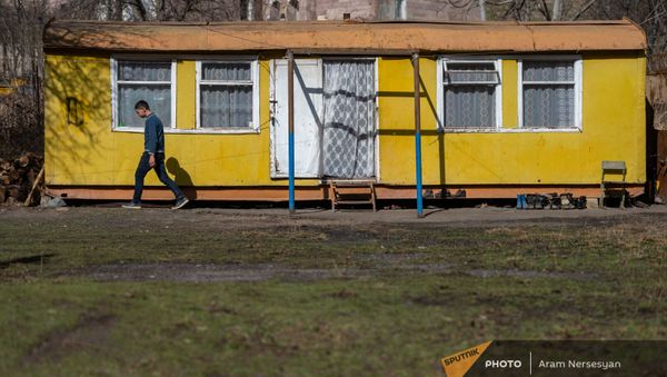 Молодой житель села Неркин Ханд в Сюникской области на фоне своего домика - Sputnik Армения