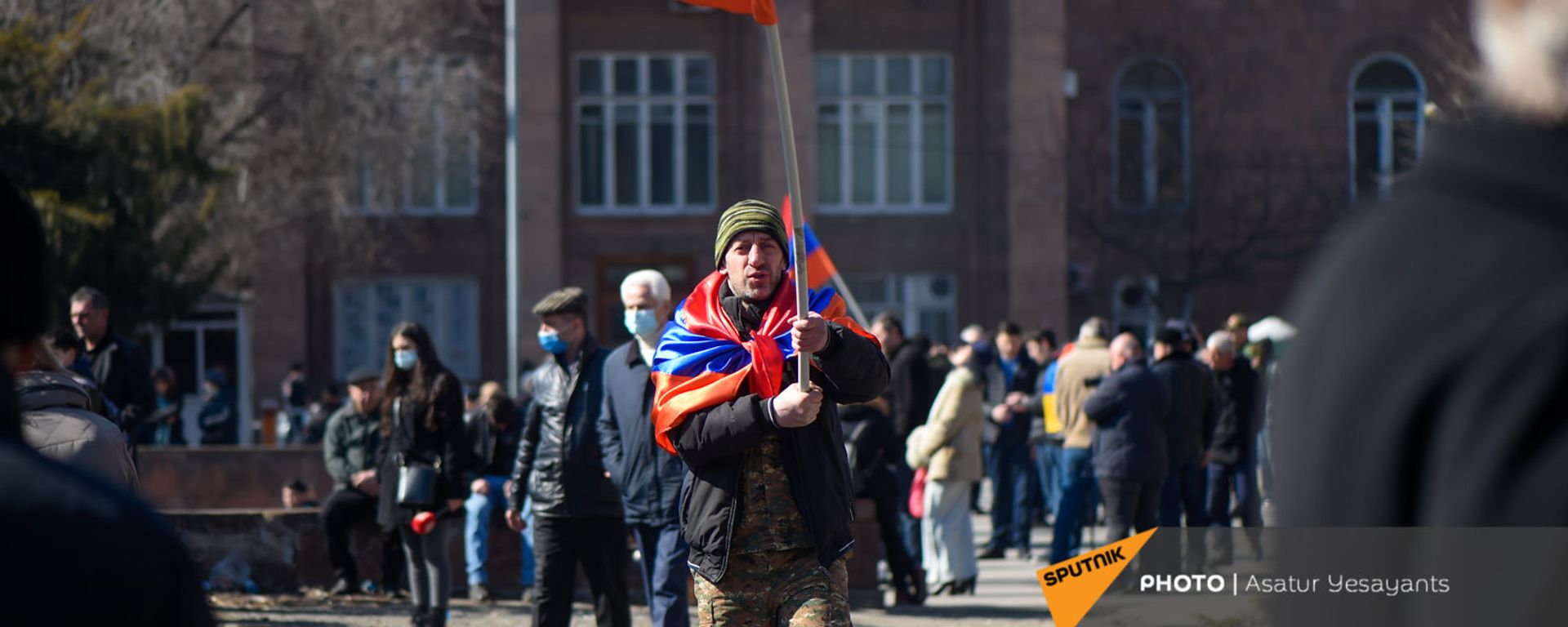 Оппозиционер с флагами на плечах и в руках перед началом акции оппозиции на перекрытом проспекте Баграмяна (26 февраля 2021). Еревaн Оппозиционер с флагами на плечах и в руках перед началом акции оппозиции на перекрытом проспекте Баграмяна (26 февраля 2021). Еревaн - Sputnik Արմենիա, 1920, 27.02.2021
