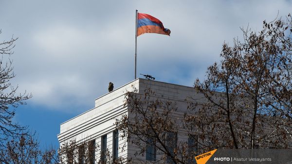 Сотрудник правоохранительных органов рядом с винтовкой на крыше здания МИД Армении (13 марта 2021). Еревaн - Sputnik Армения