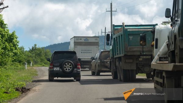 Автомобиль с армянскими номерами проезжает мимо азербайджанской колонны на дороге Шуши - Кармир Шука - Sputnik Армения