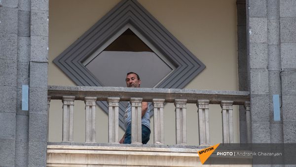 Мужчина наблюдает за митингом движения 5165 с требованием опубликовать договор с Азербайджаном (22 мая 2021). Еревaн - Sputnik Армения