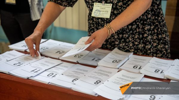 Сотрудник избирательной комиссии собирает пакет бюллетеней в избирательном участке 29/29 (20 июня 2021). Ариндж - Sputnik Армения