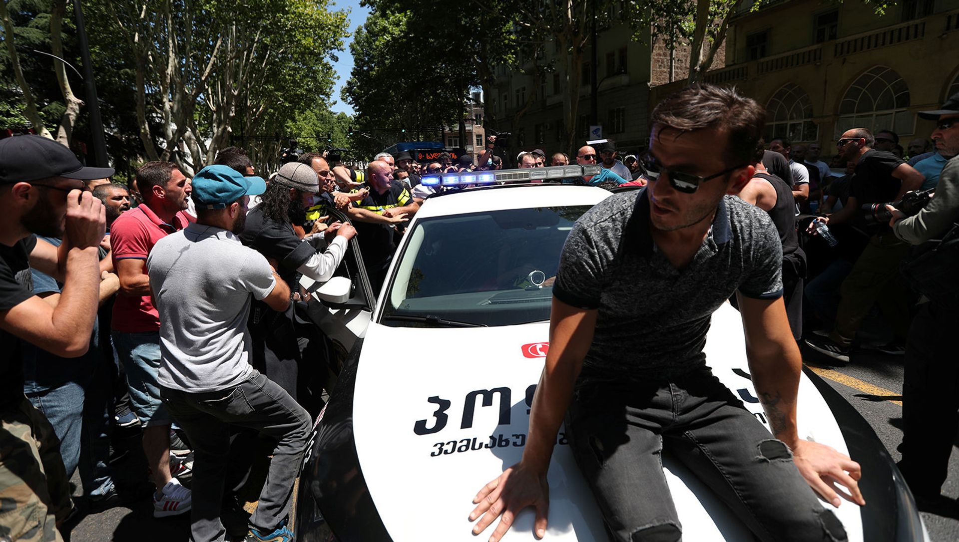 Протестующие пытаются заблокировать полицейскую машину во время митинга перед запланированным Маршем достоинства (5 июля 2021). Тбилиси Протестующие пытаются заблокировать полицейскую машину во время митинга перед запланированным Маршем достоинства (5 июля 2021). Тбилиси - Sputnik Армения, 1920, 11.07.2021