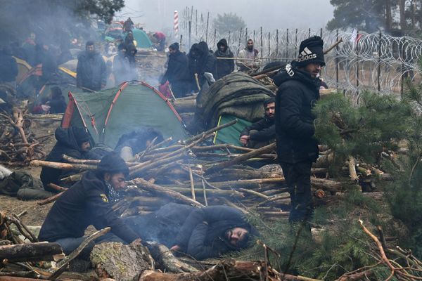 Беженцы возле заграждения из колючей проволоки в лагере нелегальных мигрантов на белорусско-польской границе - Sputnik Армения