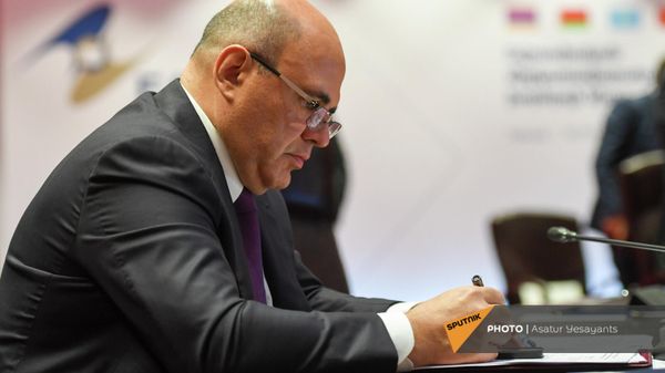 Председатель правительства России Михаил Мишустин подписывает документы на заседании Евразийского межправительственного совета (19 ноября 2021). Еревaн - Sputnik Армения