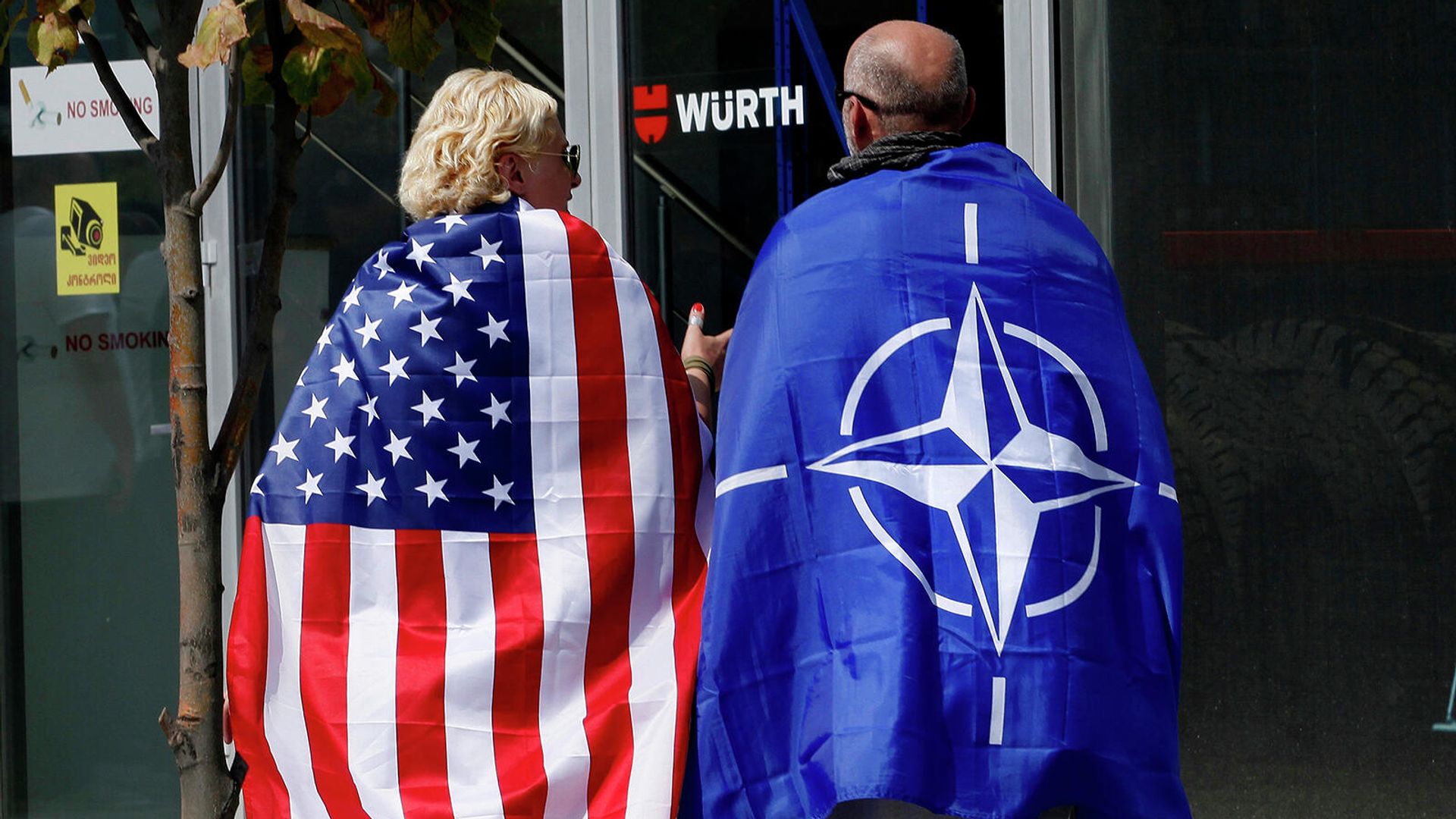 Люди с флагами США и НАТО на плечах - Sputnik Армения, 1920, 06.09.2023
