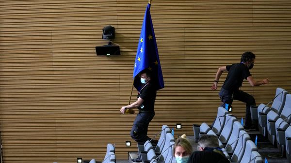 Сотрудник протокола с флагом ЕС перед пресс-конференцией генсека НАТО Йенса Столтенберга, президента Европейской комиссии Урсулы фон дер Ляйен и председателя ЕС Шарля Мишеля (24 февраля 2022). Брюссель - Sputnik Армения
