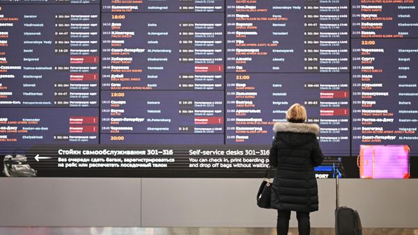 Женшина перед электронным табло с отмененными рейсами в терминале Международного аэропорта Шереметьево - Sputnik Армения