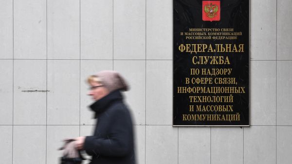 Женщина проходит мимо вывескы Федеральной службы по надзору в сфере связи, информационных технологий и массовых коммуникаций (26 октября 2017). Москвa - Sputnik Армения