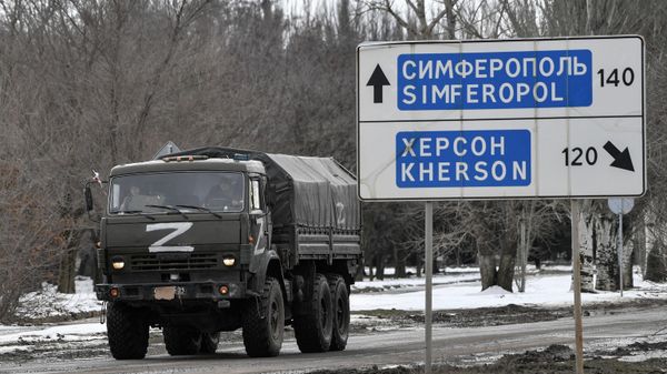 Дорожный указатель  с направлениями на Херсон и Симферополь рядом с грузовым автомобилем ВС РФ на шоссе в районе границы Крыма с Украиной - Sputnik Армения