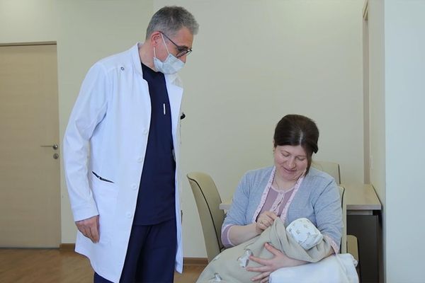 Замдиректора роддома МЦ Эребуни Давид Абовян наблюдает за новорожденным Кареном Мирзояном и его мамой Араксией Мкртумян - Sputnik Армения