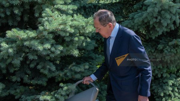 Министр иностранных дел России Сергей Лавров поливает посаженную им ель в мемориальном комплексе Цицернакаберд (9 июня 2022). Еревaн - Sputnik Армения