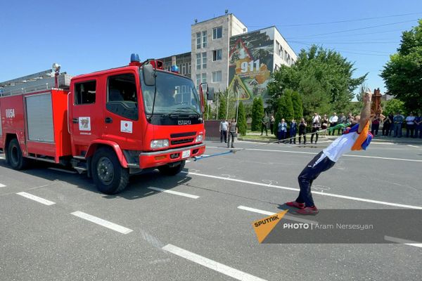Юрий Сакунц во время установления им нового мирового рекорда по перетягиванию зубами пожарных машин (16 июня 2022). Еревaн Юрий Сакунц во время установления им нового мирового рекорда по перетягиванию зубами пожарных машин (16 июня 2022). Еревaн - Sputnik Армения