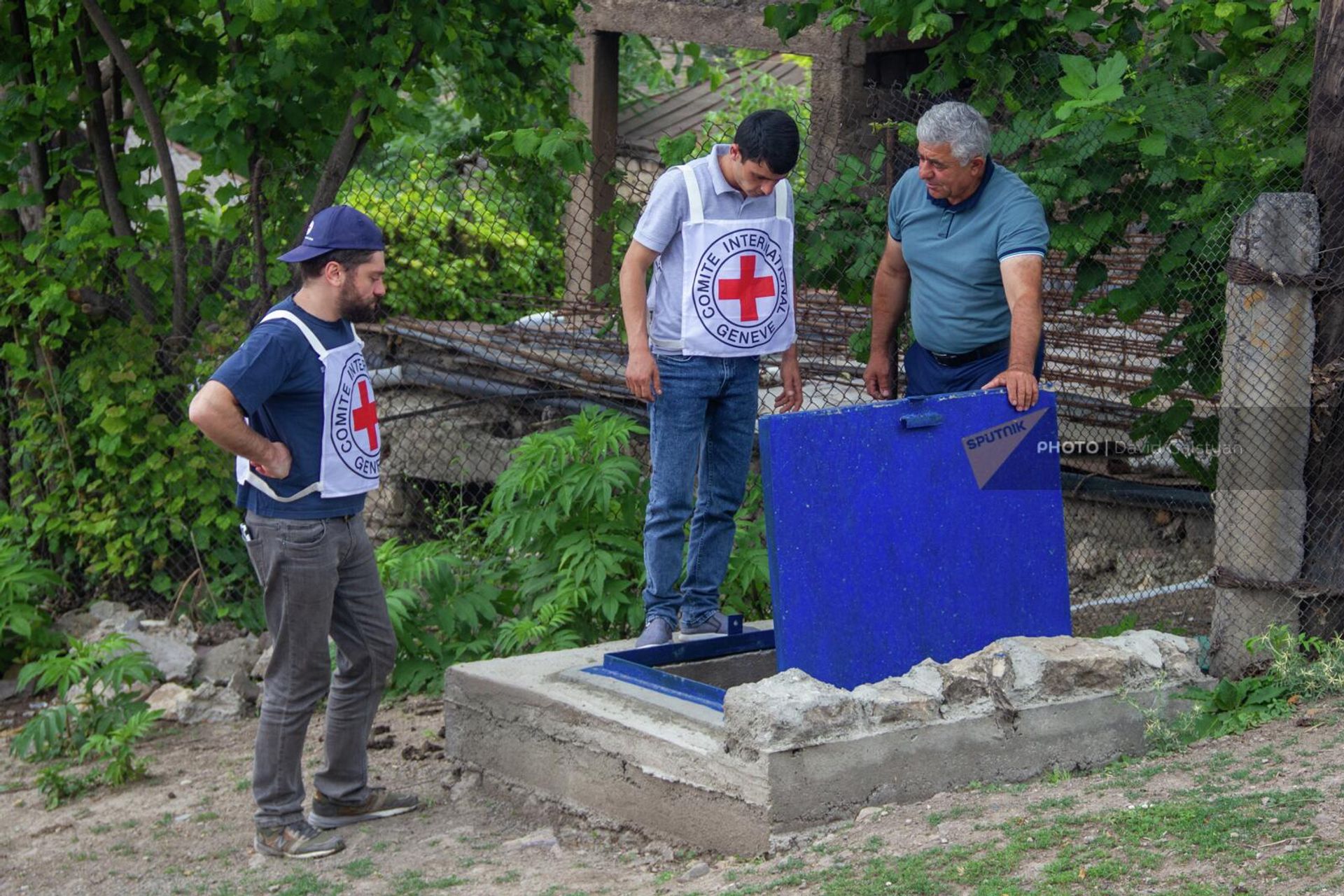 Бывший староста села Егвард Сюникской области Спартак Закарян с сотрудниками МККК у смотрового колодца - Sputnik Армения, 1920, 29.06.2022