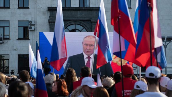 Жители Луганска смотрят трансляцию выступления президента РФ Владимира Путина на церемонии подписания договоров о вхождении в РФ Донецкой и Луганской народных республик, Запорожской и Херсонской областей (30 сентября 2022). ЛНР - Sputnik Армения