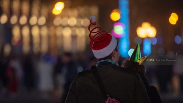 Молодые люди в праздничный головных уборах на площади Республики в Новогоднюю ночь - Sputnik Армения