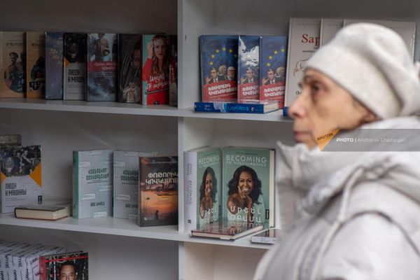 Женщина рассматривает полки с книгами на акции "Читаем на армянском" - Sputnik Армения