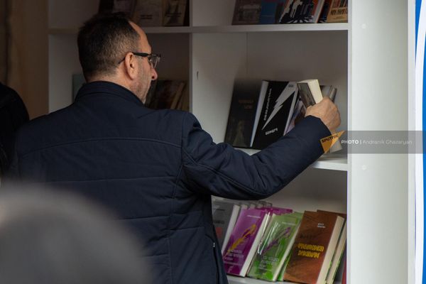 Мужчина рассматривает книжные новинки на акции "Читаем на армянском" - Sputnik Армения