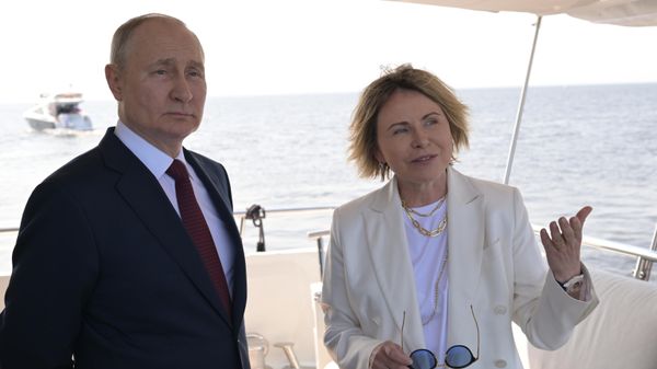 Президент РФ Владимир Путин и заместитель генерального директора компании Газпром нефть, генеральный директор ООО Газпром Лахта Елена Илюхина наблюдают за церемонией подъёма  государственных флагов Российской Федерации, СССР и Российской империи (17 июня 2023). Санкт-Петербург - Sputnik Армения