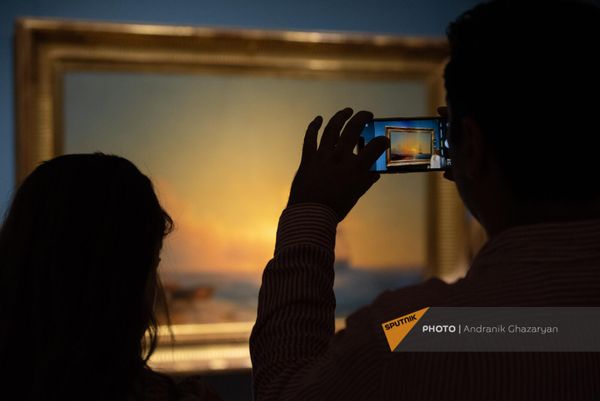 Один из посетителей экспозиции фотографируют картину Айвазовского - Sputnik Армения