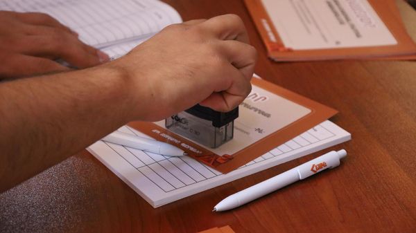 Волонтер ставит штамп на сертификат участника Айакве - Sputnik Արմենիա