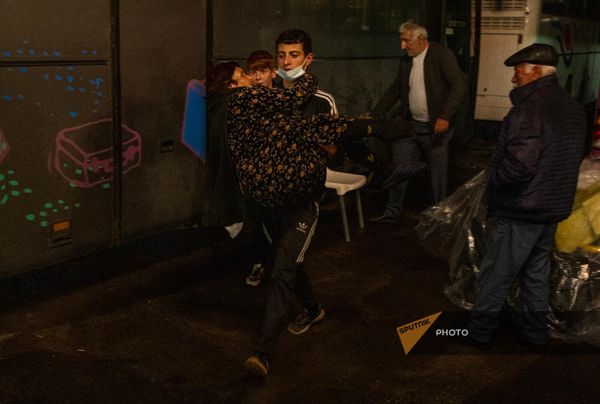 Волонтер Армянского общества "Красного креста" несет на руках одинокую и приболевшую бабушку. - Sputnik Армения