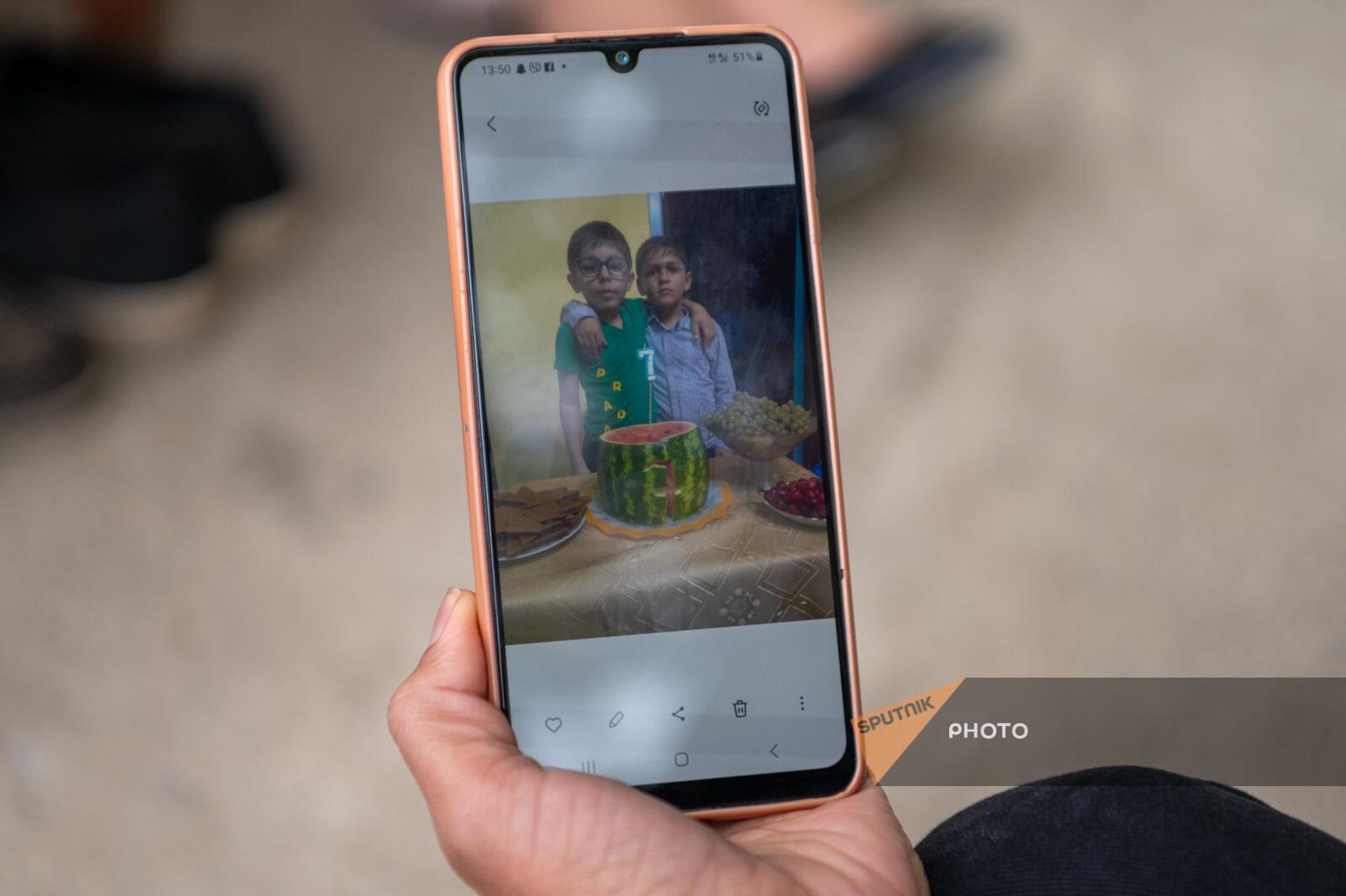 Вынужденная переселенка Лилит показывает фотографию празднования дня рождения сына во время блокады в Нагорном Карабахе - Sputnik Армения, 1920, 06.10.2023