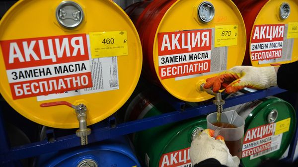 Сотрудник сети центров по обслуживанию автомобилей наливает моторное масло в специальную емкость - Sputnik Армения