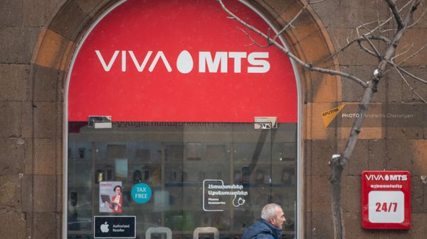 Мужчина проходит мимо офиса Viva-MTS в Еревaне - Sputnik Армения