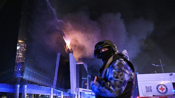 Сотрудник силовых структур у концертного зала Крокус Сити Холл, где произошла стрельба (22 марта 2024). Москва - Sputnik Армения