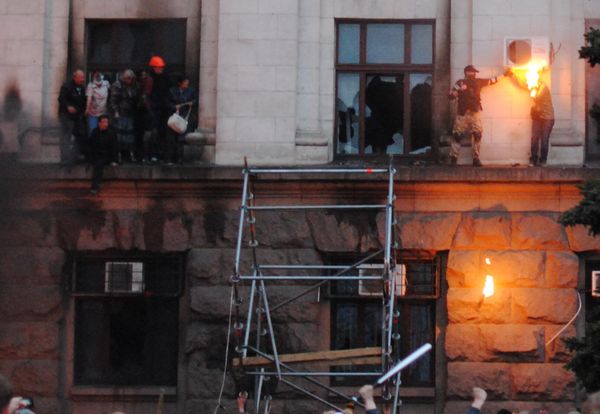 Люди выбрались на карниз во время пожара в Доме профсоюзов в Одессе. Справа: на лицо и волосы девушки попал тряпичный кляп с горючей смесью от брошенной бутылки "коктейля Молотова" - Sputnik Армения