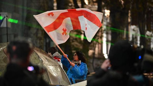 Активистка с флагом Грузии во время разгона протеста оппозиции спецназом (30 ноября 2024). Тбилиси - Sputnik Армения