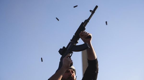 Боец оппозиции стреляет из своего АК-47 в воздух, празднуя победу оппозиционных сил над городом Дамаск (8 декабря 2024). Сирия - Sputnik Армения