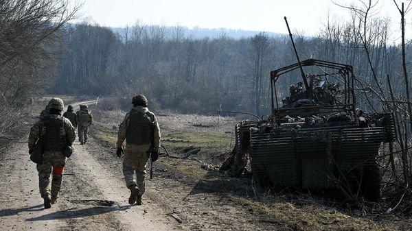 Военнослужащие ВС РФ рядом со сгоревшим бронеавтомобилем ВСУ БТР-4 Буцефал на территории освобожденной деревни Новая Сорочина в Суджанском районе (9 марта 2025). Курская область - Sputnik Армения
